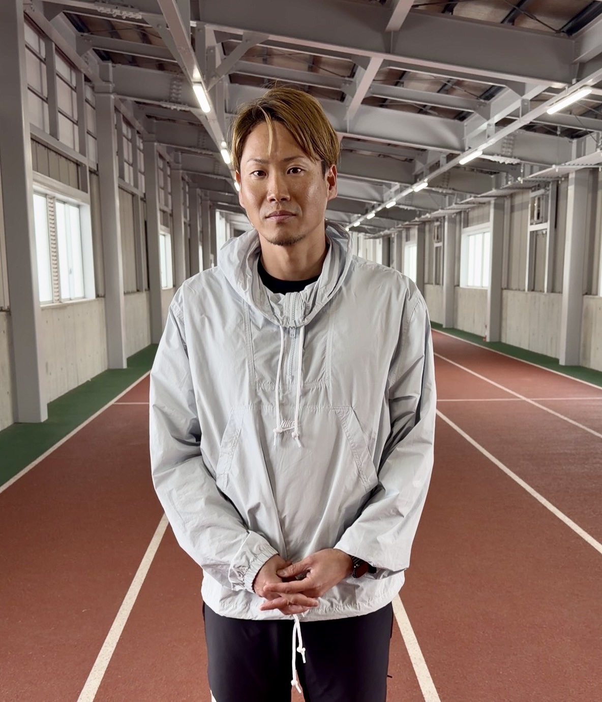 屋内トラックに立つ講師のポートレート