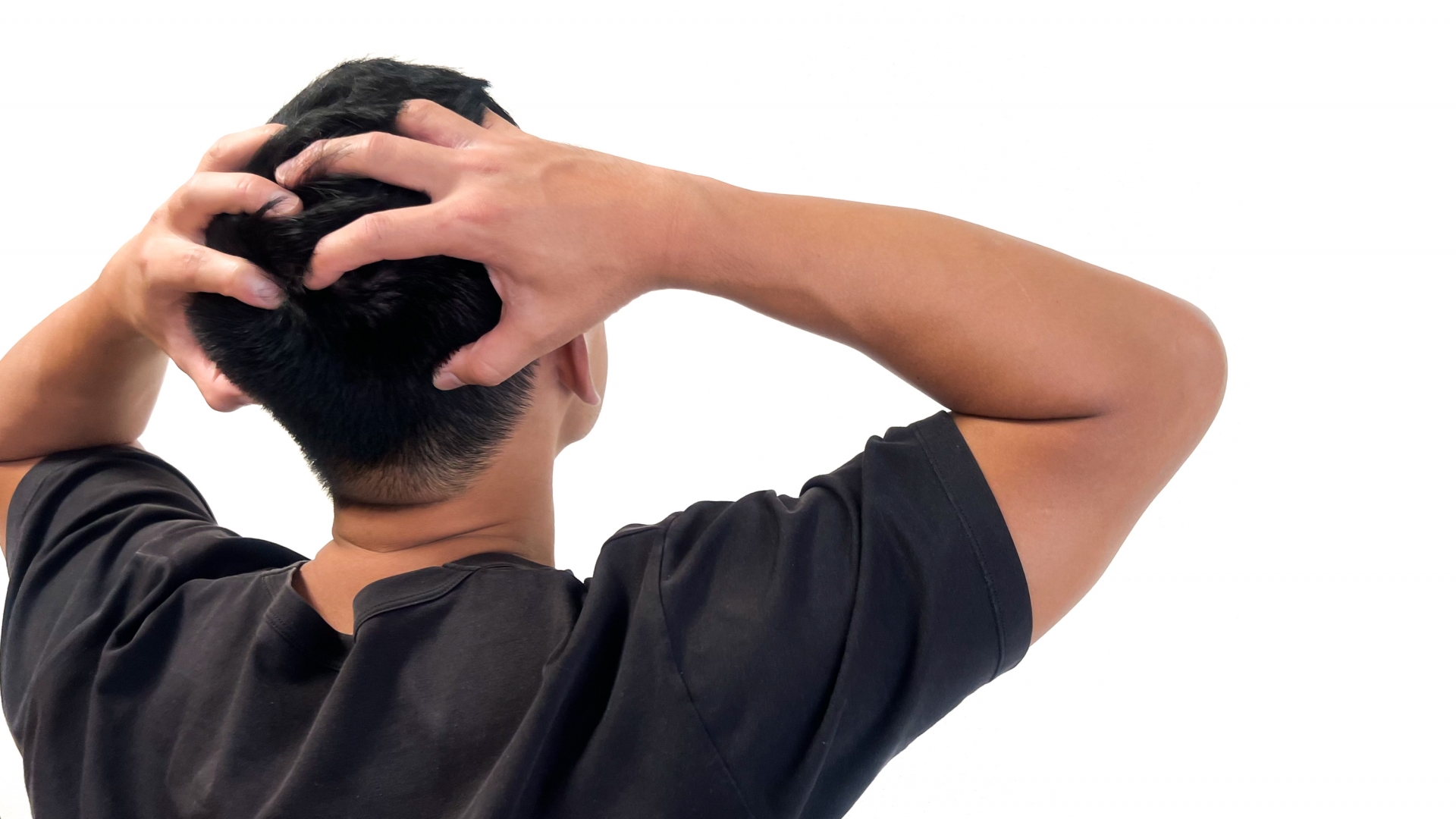 頭を抱えて悩む人物の後ろ姿