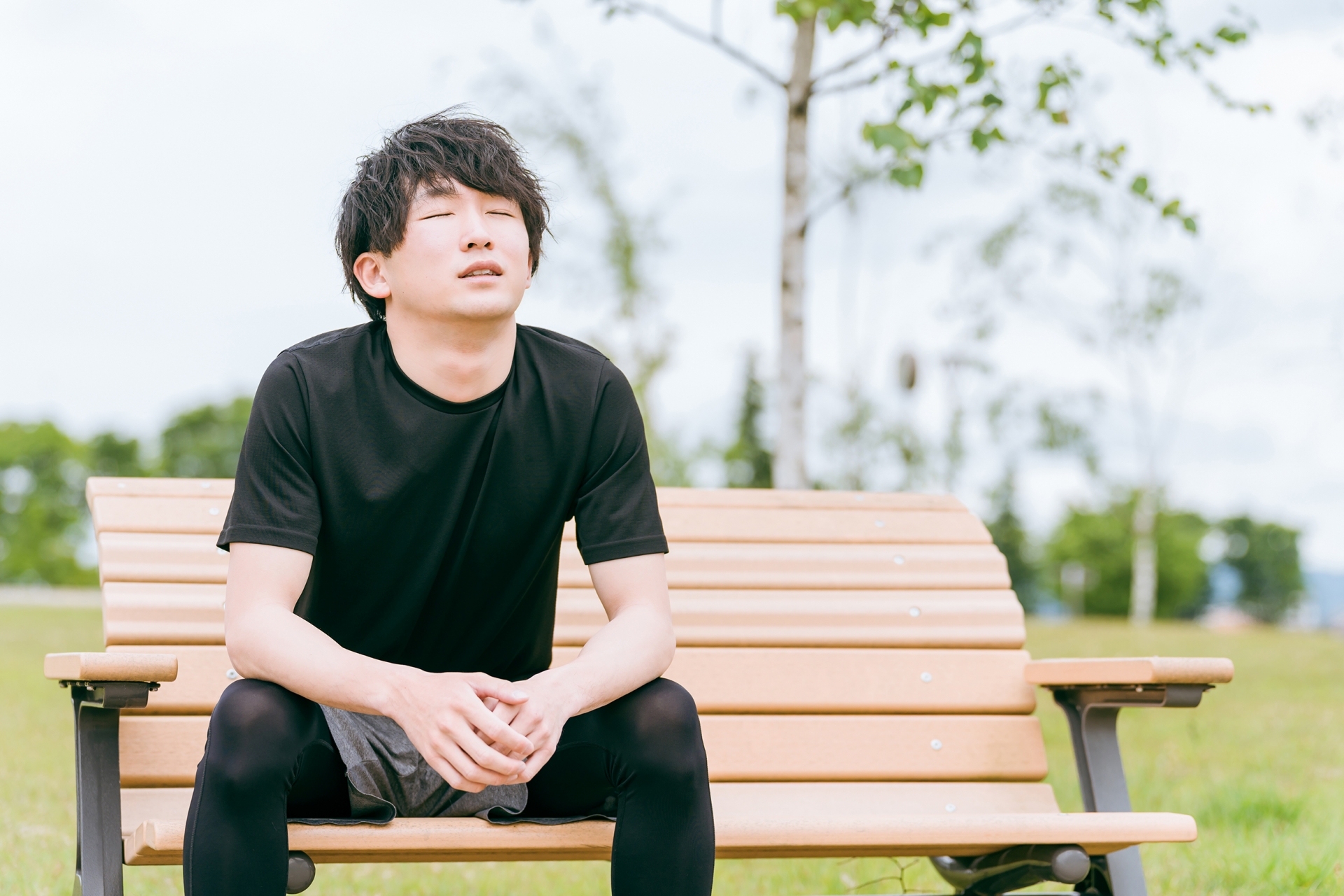 ベンチに座り疲弊した表情のアスリート